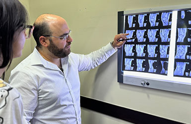 Especialista revisa con un paciente adulto una resonancia de rodilla durante la consulta.